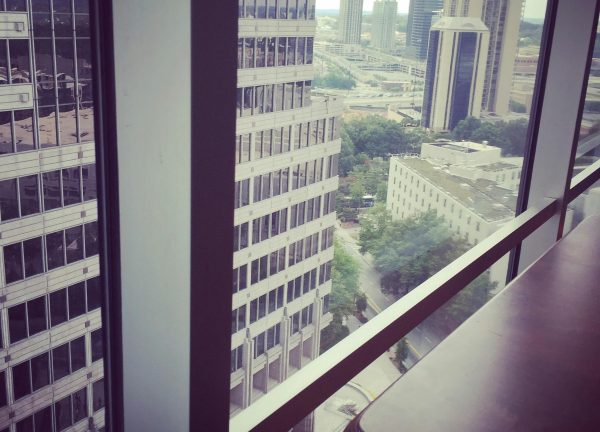 Window view of modern city skyline and skyscrapers from a high-rise office.